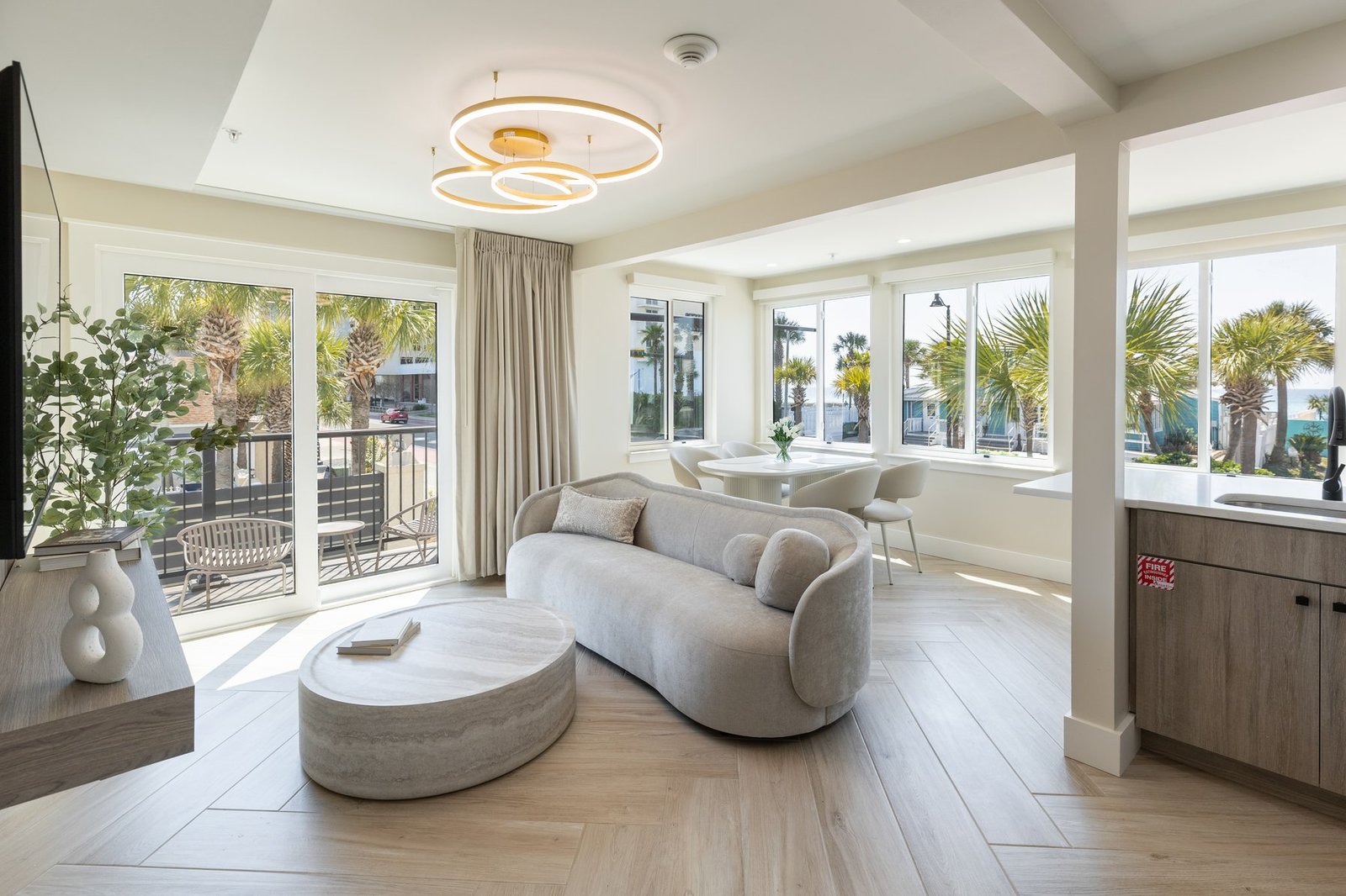 Ocean view suite living area at Octa Collection, with floor-to-ceiling windows overlooking palm trees