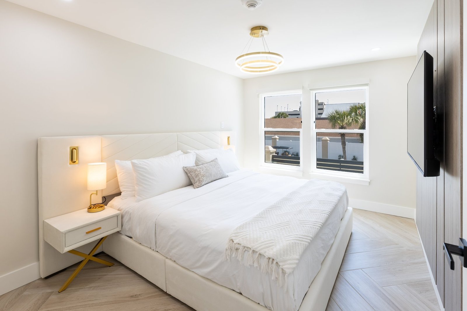 Deluxe King bedroom with balcony view of palm trees